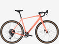 Coral bicycle with black components on a white background