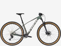 Mountain bike with a green frame and tan tires on a white background