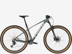 Mountain bike with a green frame and tan tires on a white background