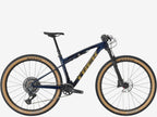 Mountain bike with blue frame and tan tires on a white background